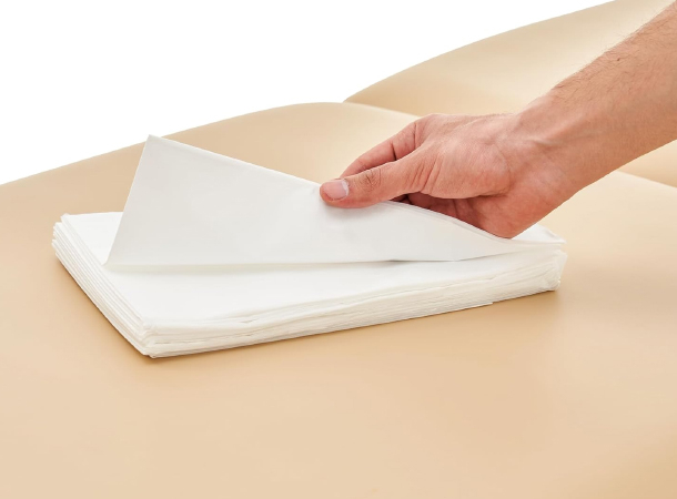 Sealed pack of 100 disposable waterproof sheets for massage beds.